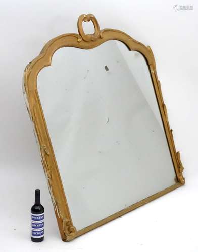 A late 19thC / early 20thC gilt painted mirror with a shaped top and moulding's.