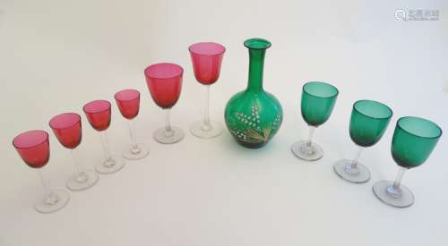 Assorted Cranberry and green glassware including pedestal drinking glasses and a carafe.