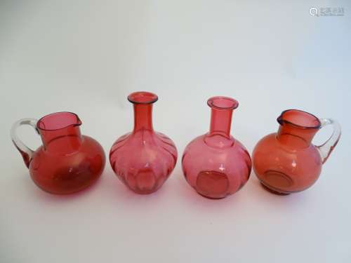 4 assorted items of cranberry glass comprising jugs and carafes.