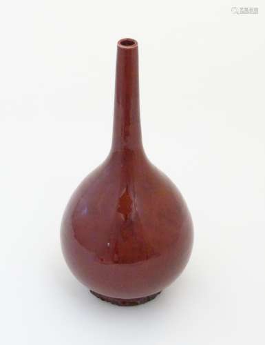 A Chinese globular vase with a slender, elongated neck with a sang de boeuf glaze. Approx.