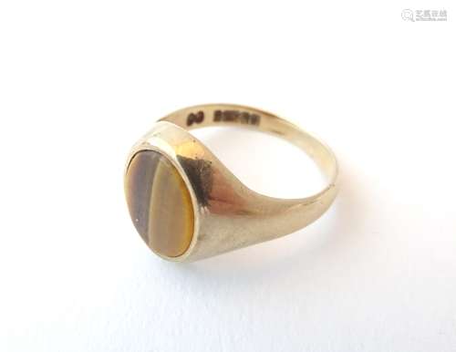 A 9ct gold gentleman's ring set with tigers eye cabochon. Ring size approx.