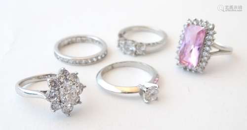 A collection of five assorted silver rings.