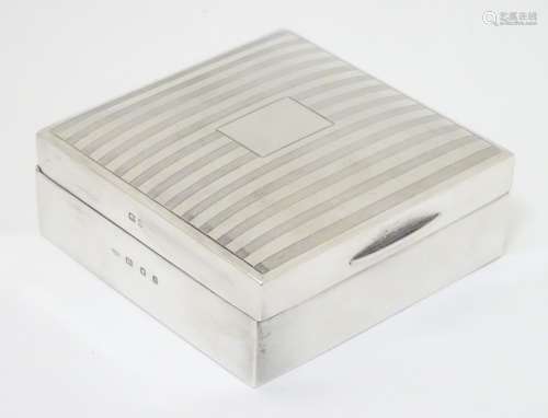 A silver table top cigarette box with banded engine turned decoration hallmarked London 1932 maker