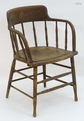 An early 20thC smokers bow chair with turned finial supports and anthemion decorated seat,