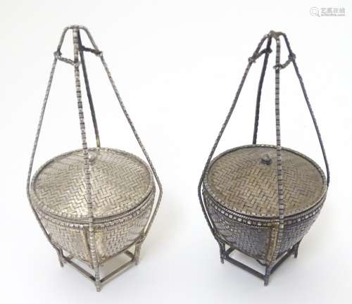 A pair of white metal pot and covers formed as a small woven lidded baskets .