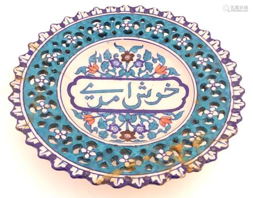 A 19thC Persian dish with Islamic script to the centre surrounded by stylised flowers and foliage,