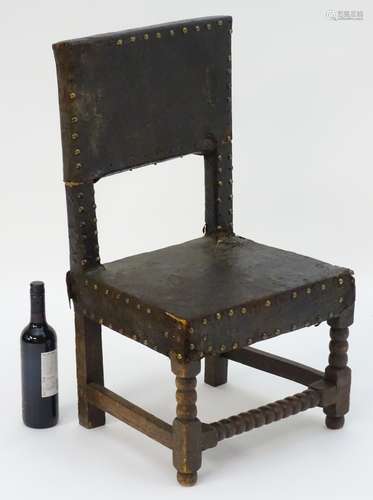 A 17thC childs chair with leather upholstery and brass stud detailing with block and bobbin turned