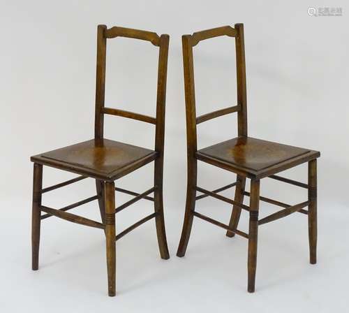 An pair of early 20thC beech chairs with shaped top rails and shell decorated seats above turned