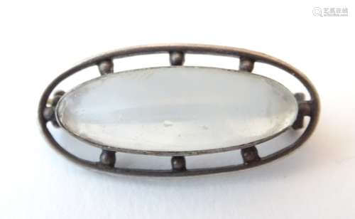 An Art Deco silver brooch set with central moonstone cabochon. marked Sterling Silver.