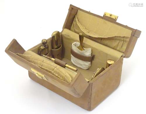 A 20thC leather necessaire / travelling vanity case, the case comprising 6 gilt metal items,