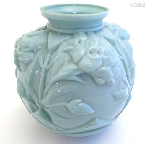 An Art Deco pale green glass vase with moulded floral decoration.