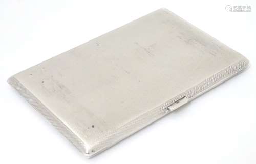 An Art Deco silver cigarette case with engine turned decoration.