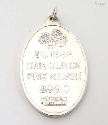 A silver pendant with rose decoration. Titled 'Suisse One ounce Fine Silver 999.