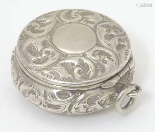 An early 20thC silver compact of pot form, with embossed acanthus scroll decoration and hinge lid,