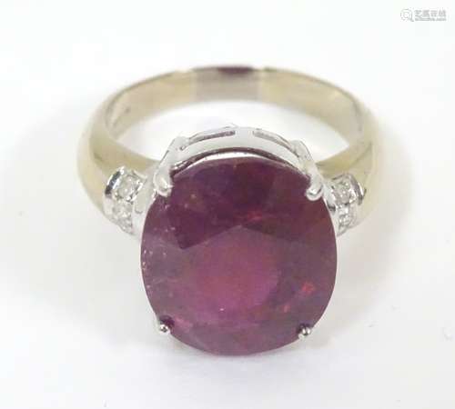 An 18ct white gold ring set with large oval red spinel flanked by diamonds. Ring size approx.