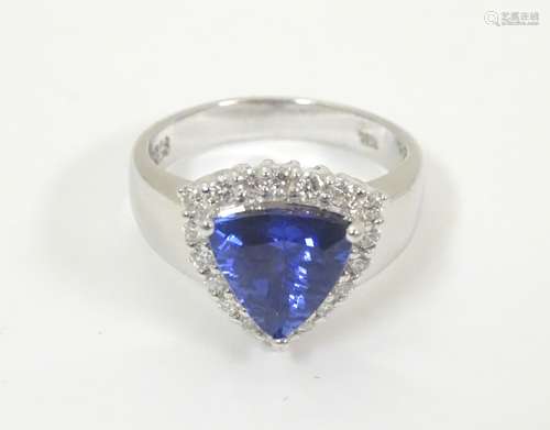 An 18ct white gold ring set with central iolite bordered by diamonds. Ring size approx.