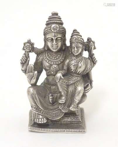 A silver miniature model of a seated deity with child.