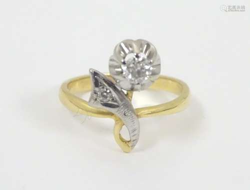 A 18ct gold ring set with 2 diamonds in a stylised floral setting. The largest diamond approx .20ct.