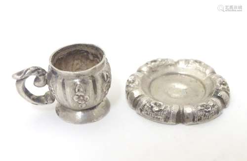 A Continental silver miniature dolls house cup and saucer.