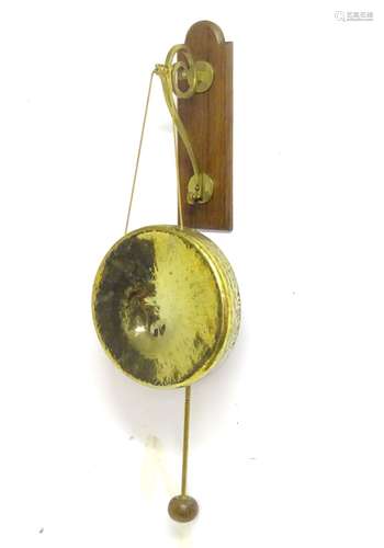 A c1900 wall hanging gong, affixed to a brass and oak hanger, with associated mallet,