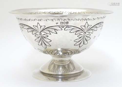 A silver pedestal bowl with embossed decoration.