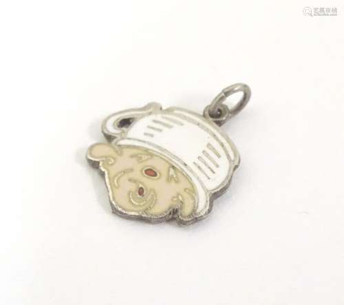 A mid 20thC novelty white metal pendant charm formed as a humorous face wearing a chamber pot as a