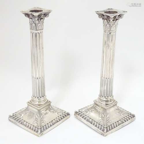 A pair of silver candlesticks of Corinthian column form.