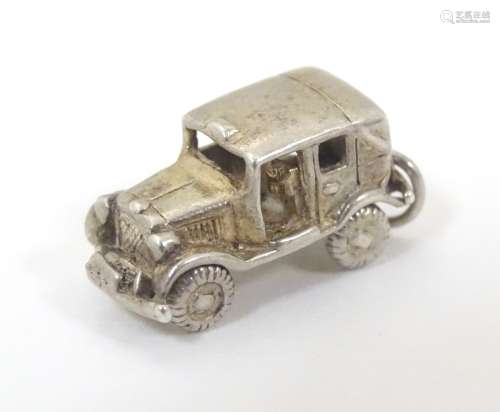 A novelty silver pendant charm formed as a vintage motor car with articulated wheels. Approx.