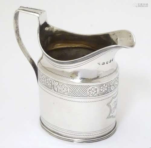 A Geo III silver jug with bright cut banded decoration. Hallmarked London 1800 maker SH.