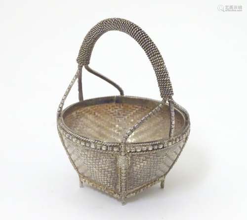 A white metal dish formed as a woven basket.