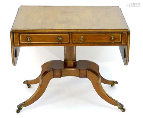 A Regency rosewood sofa table with a rectangular brass inlaid top above brass inlaid drawer fronts