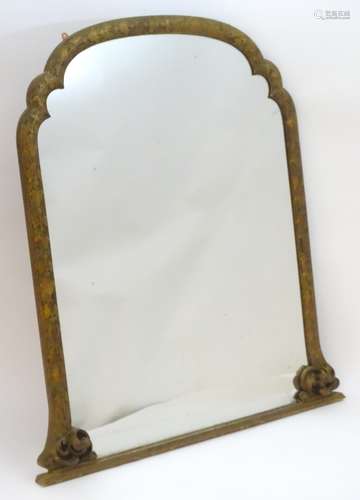 A late 19thC carved overmantle mirror with a shaped frame decorated with foliate detailing.