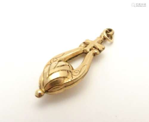 A Victorian yellow metal pendant surmounted by a cross, with engraved decoration. Approx.