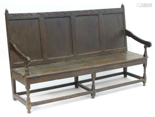 An early / mid 18thC oak settle with nulled carving to the top rail,