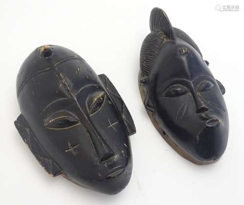 Ethnographic / Native / Tribal: A pair of ebonised wall masks with carved decoration. Each approx.