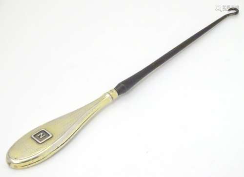 A silver handled button hook with engine turned and gilt decoration hallmarked 1912 maker Levi &
