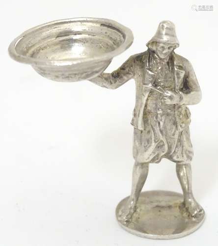 A novelty white metal pipe tamper of figural form depicting a figure wearing a fisherman's hat and