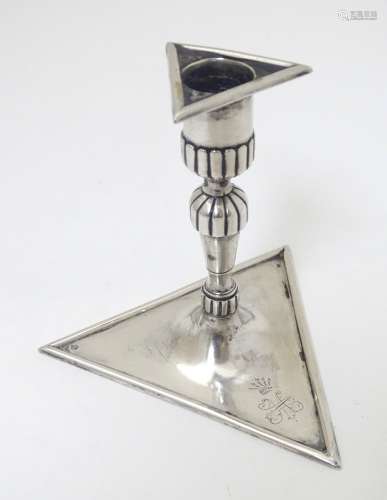 A continental silver candlestick on a triangular base. Probably French maker VJ.
