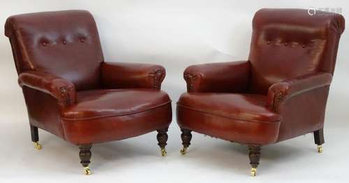 A pair of red leather armchairs with deep buttoned back rests,