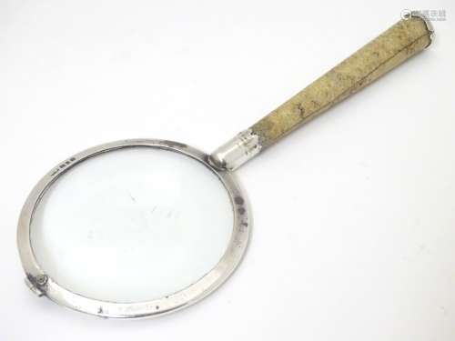 A silver magnifying glass with shagreen covered handle.