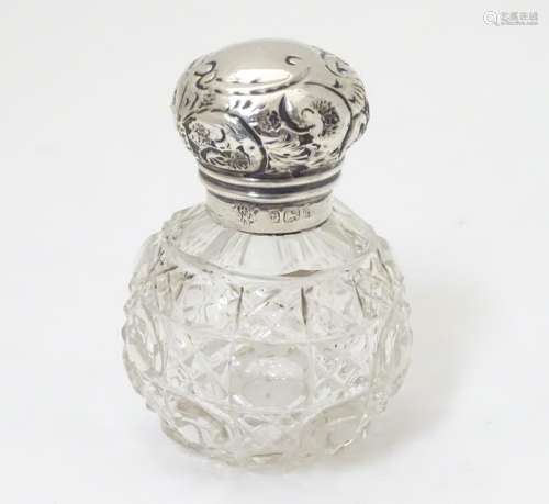 A cut glass scent bottle with silver top hallmarked Birmingham 1907 maker J H Worrall, Son & Co.