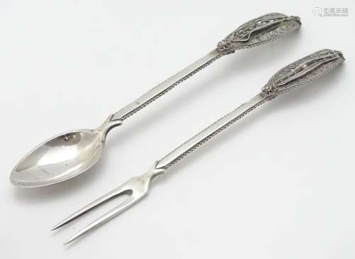 A Continental white metal fork and spoon with filigree decoration to handles.