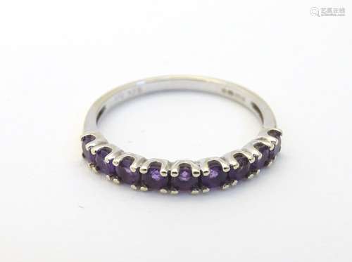 A 9ct gold ring set with 9 amethysts in a linear setting. Ring size approx.