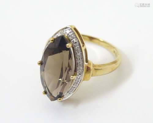 A 9ct gold ring set with marquise cut brown stone bordered by diamonds. Ring size approx.