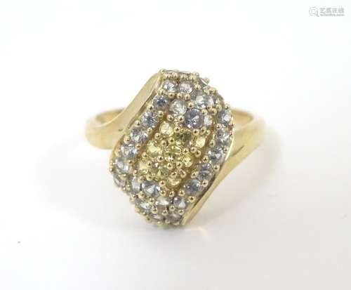 A 9ct gold dress ring set with a profusion of white and yellow stones. Ring size approx.