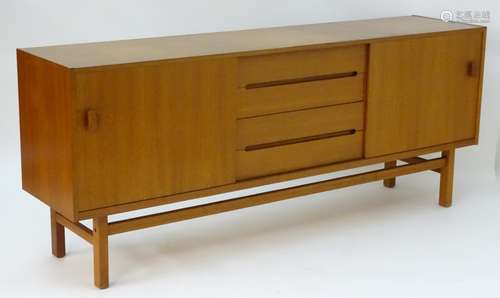 Vintage/Retro: A long teak sideboard having two sliding doors opening to reveal shelves within