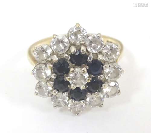 A 9ct gold dress ring set with blue and white paste stones. Ring size approx.