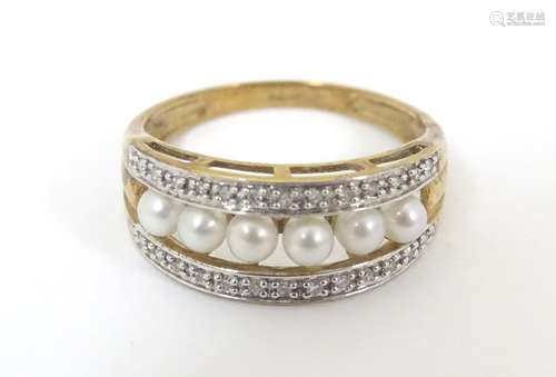 A 9ct gold ring set with a band of pearls flanked by bands of chip set diamonds. Ring size approx.