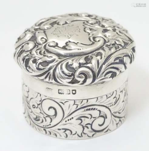 A silver pot of circular form with screw top having engraved and embossed acanthus scroll