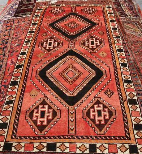 A KASHGAR CARPET, with two primary medallions and six smaller to a red ground